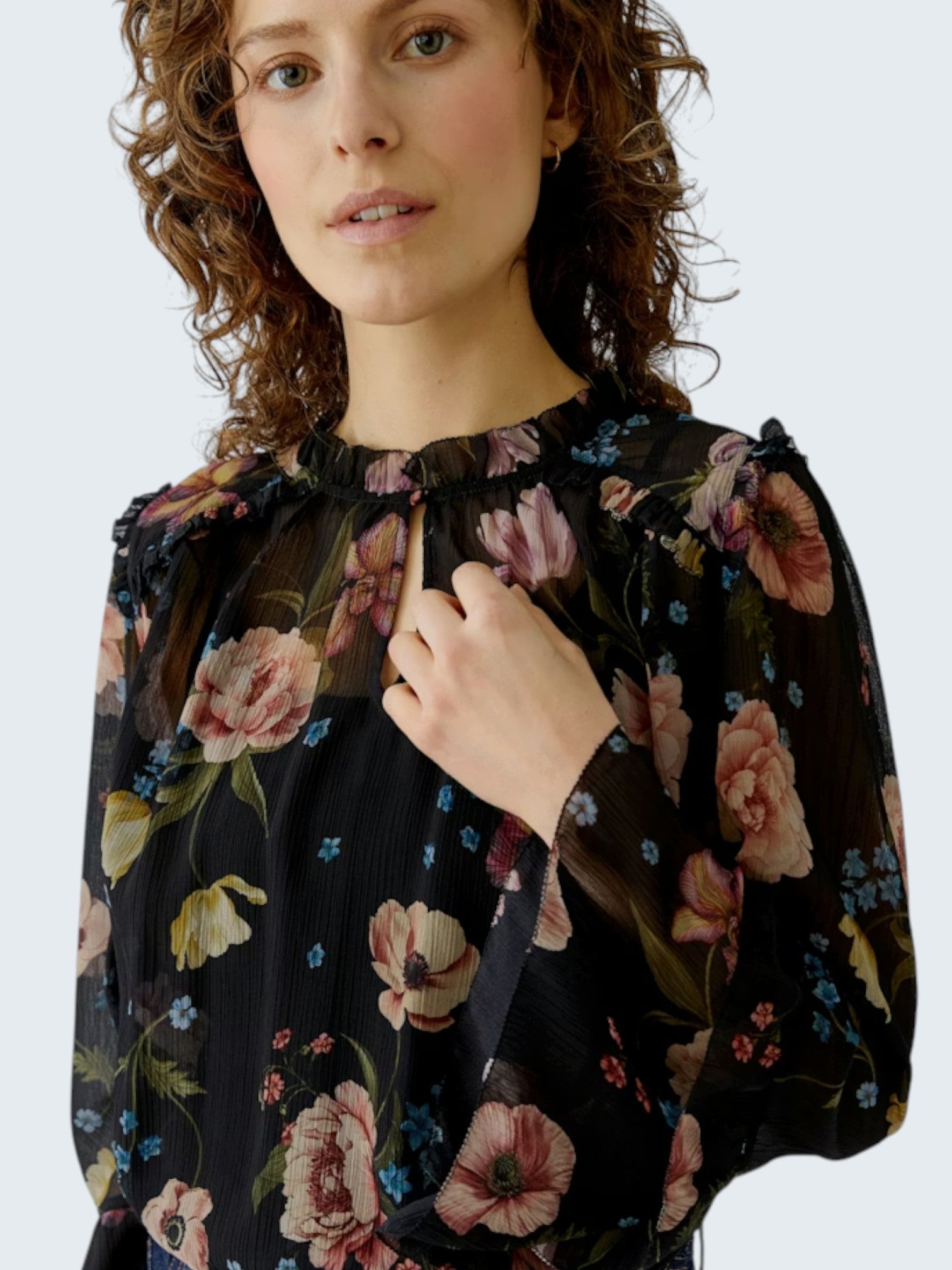 oui-ua.store black sheer chiffon boho blouse with floral print, ruffles, and wide sleeves.